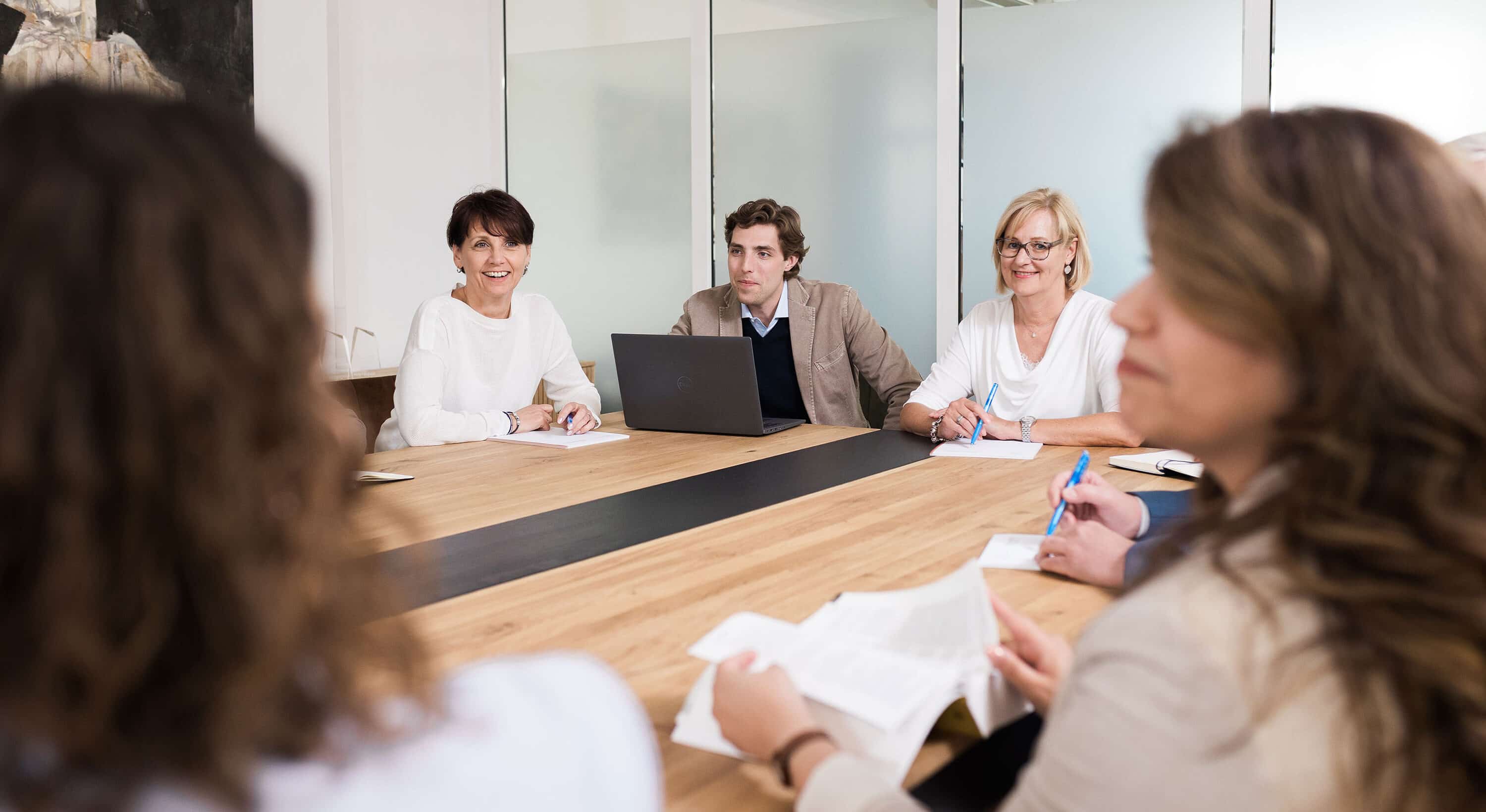 Freundliche Personen an einem Besprechungstisch